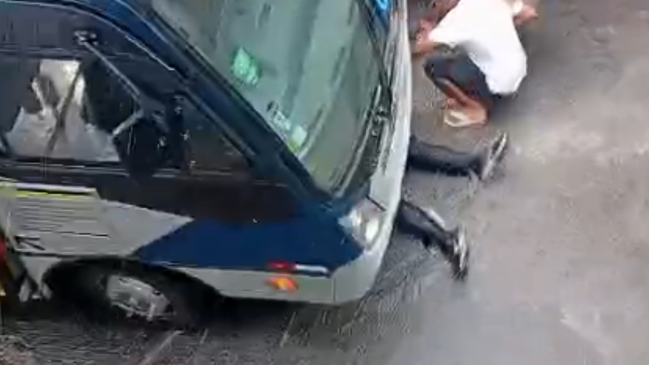 Motociclista fica preso em baixo de ônibus após ser atropelado