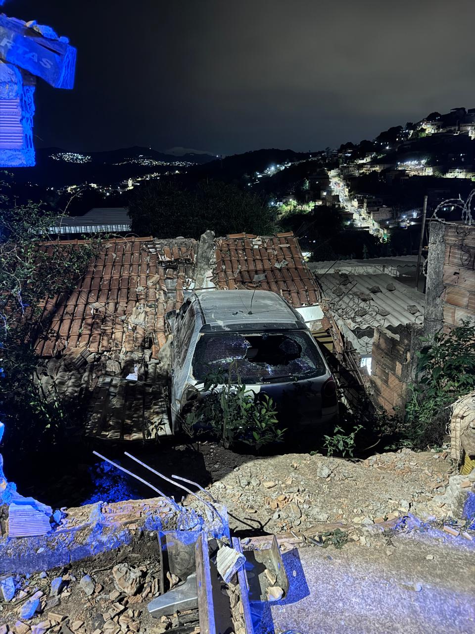 Carro bate contra muro de casa e fica suspenso sobre telhado